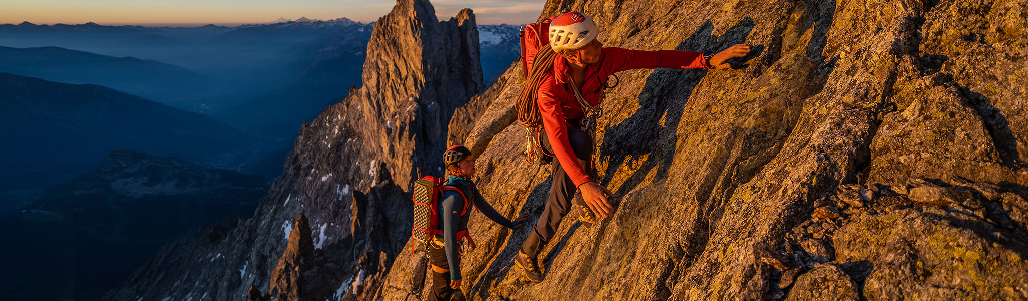 A woman wearing a Mountain Equipment jacket and helmet climbing