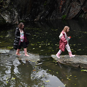 Two people walking by the water