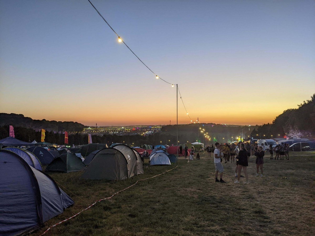 An image of a Boomtown campsite at sunset